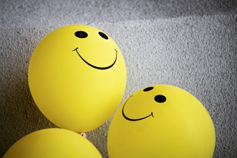 Yellow balloons with smiley faces on them.